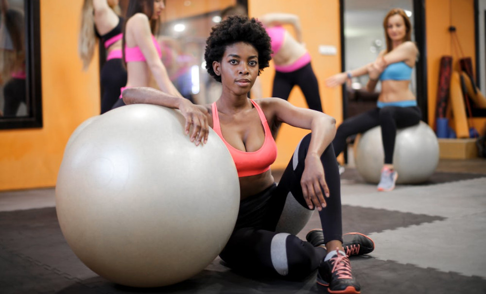 Woman leaning on large exercice ball